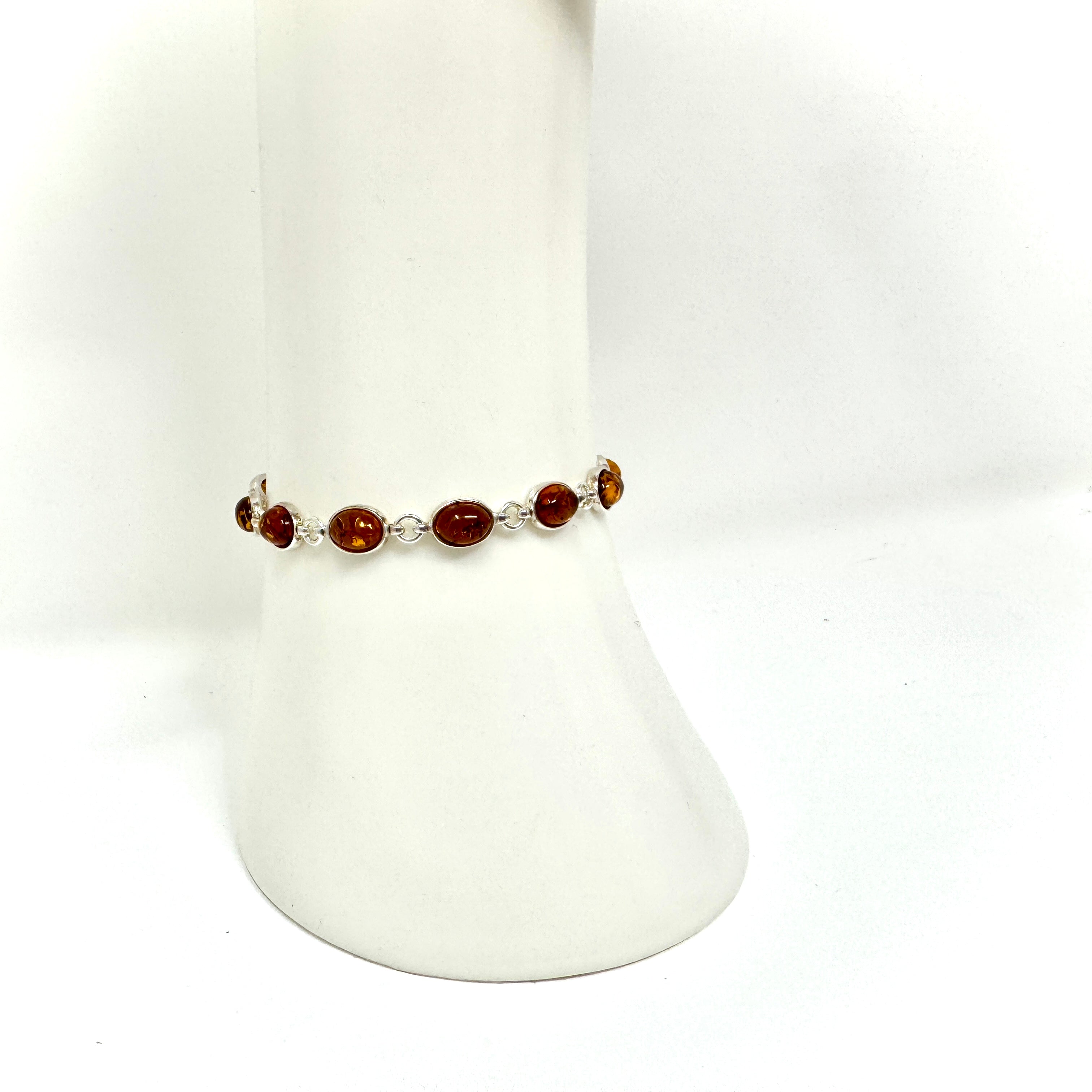 Luxuriöses Bernstein-Armband aus 925er Silber mit kunstvoll eingefassten Bernsteinen in warmen Naturtönen. Handgefertigtes Unikat mit sicherem Silberverschluss.